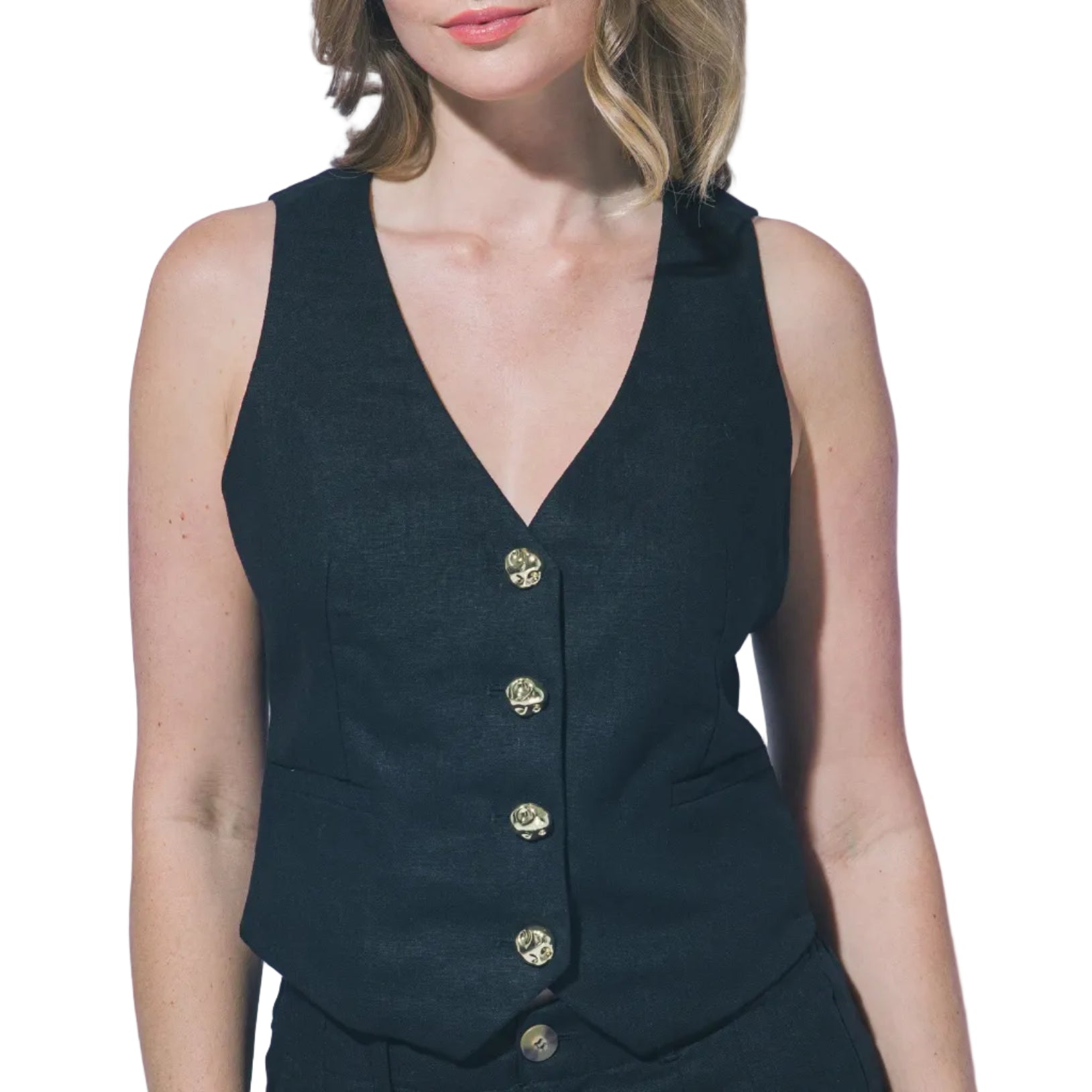 Woman wearing a black sleeveless vest with buttons on a plain background