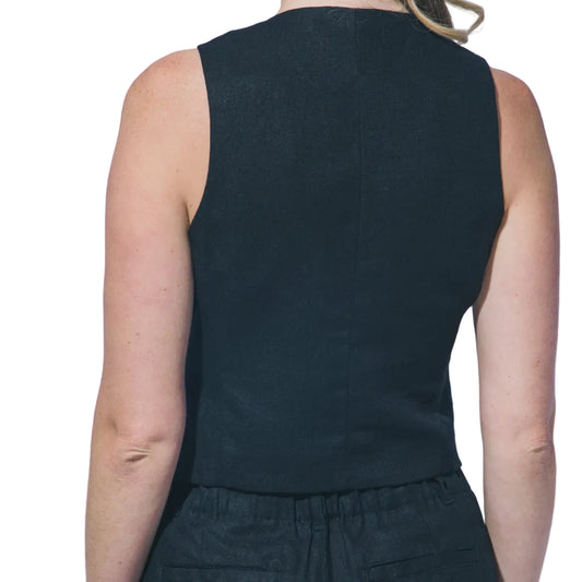 Woman wearing a black sleeveless top and shorts against a plain background