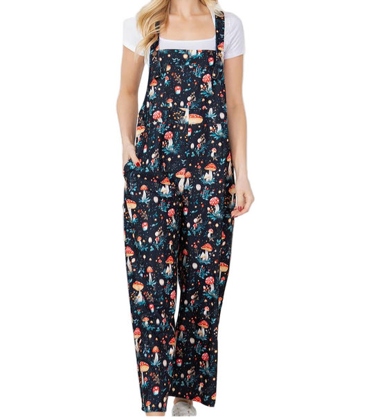 Woman wearing a floral patterned jumpsuit standing in a room with plants.