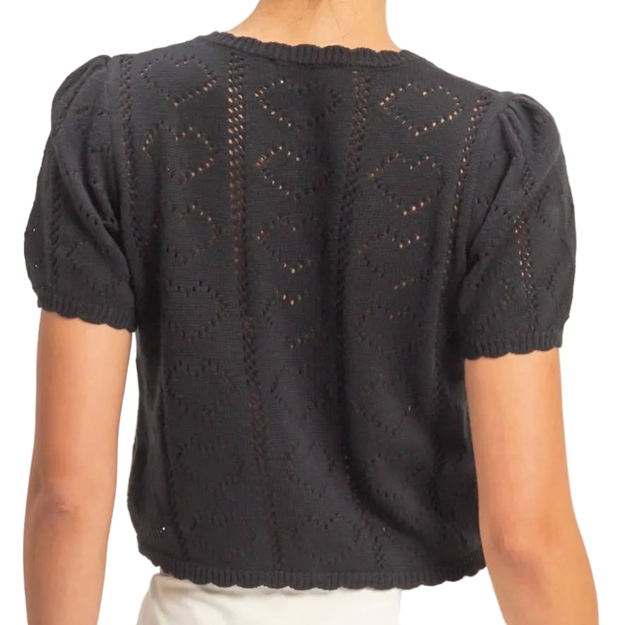 Person wearing a black top and white skirt on a plain background