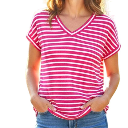 Woman wearing a pink and white striped shirt with a blurred natural background