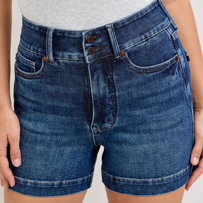 Person wearing blue denim shorts on a plain background