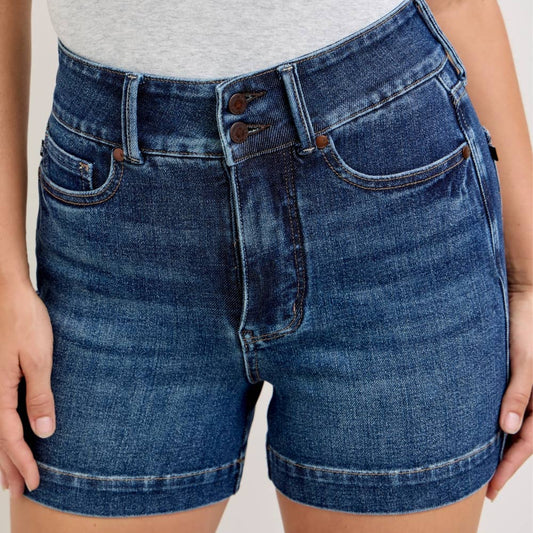 Person wearing blue denim shorts on a plain background