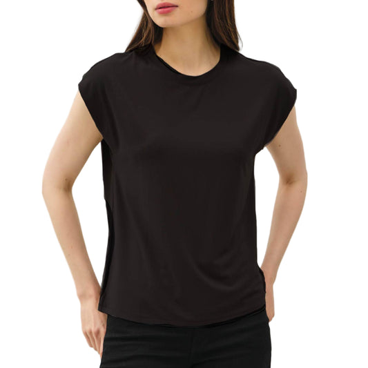 Woman wearing a black sleeveless top and black pants against a light gray background