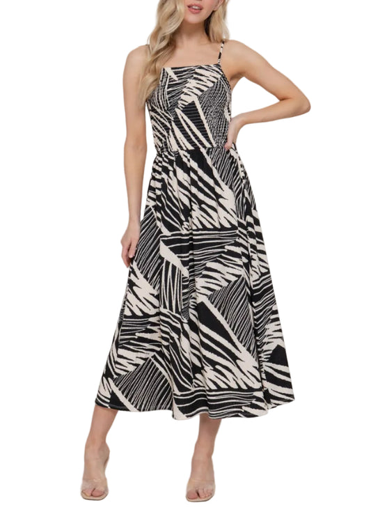 Woman wearing a black and white patterned dress against a plain background