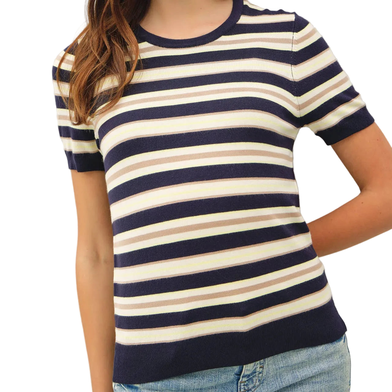 Woman wearing a navy and white striped shirt with blue jeans on a plain background