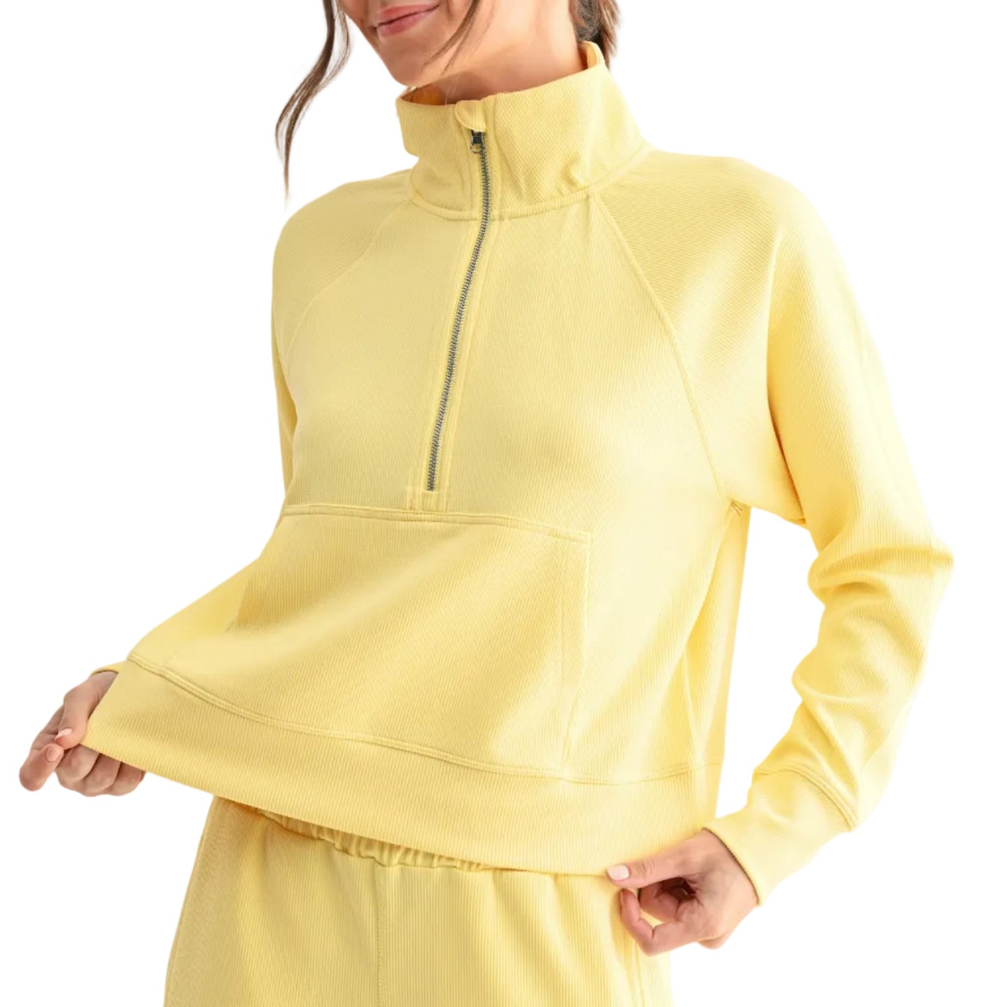 Woman wearing a yellow outfit with a quarter-zip top and pants on a white background