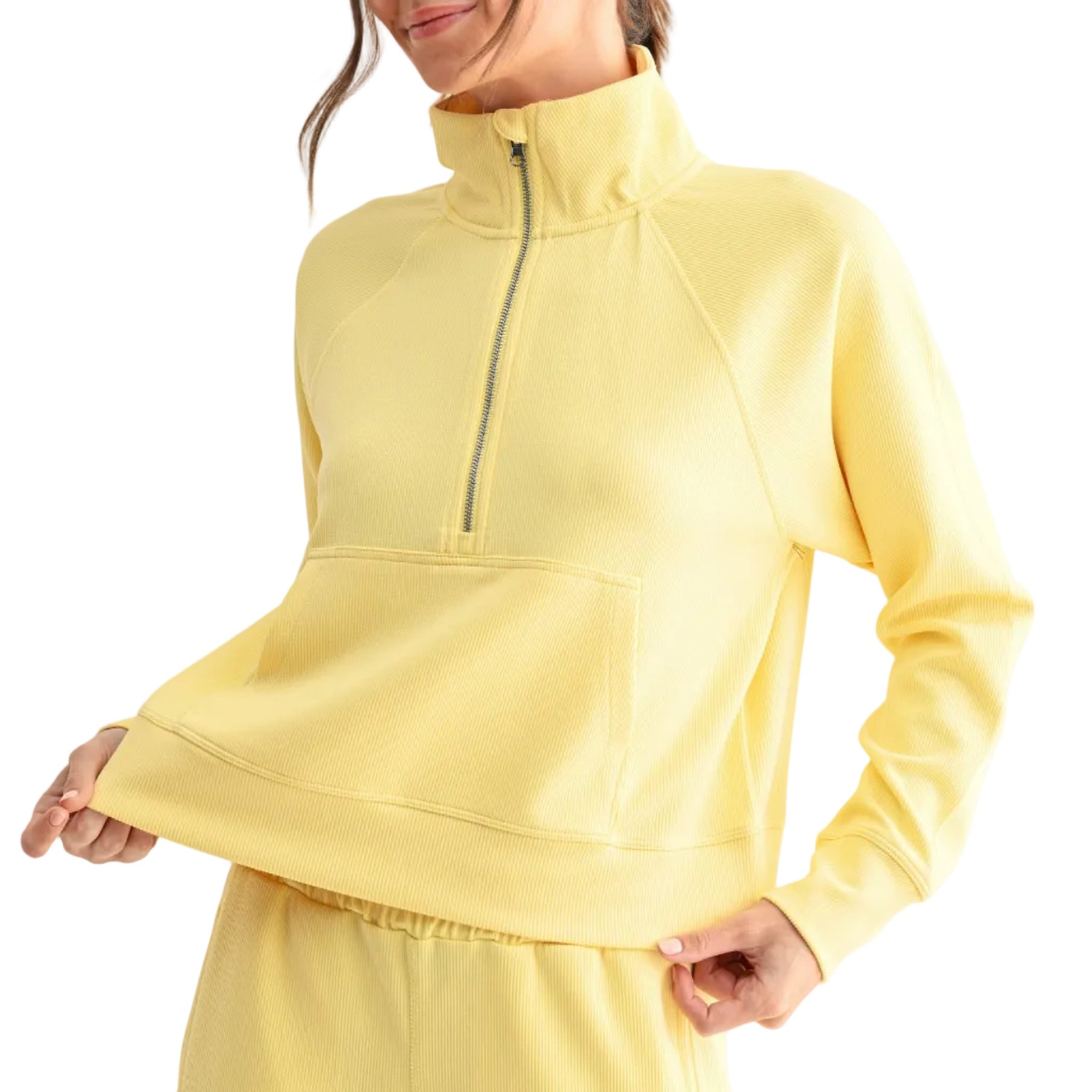Woman wearing a yellow outfit with a quarter-zip top and pants on a white background
