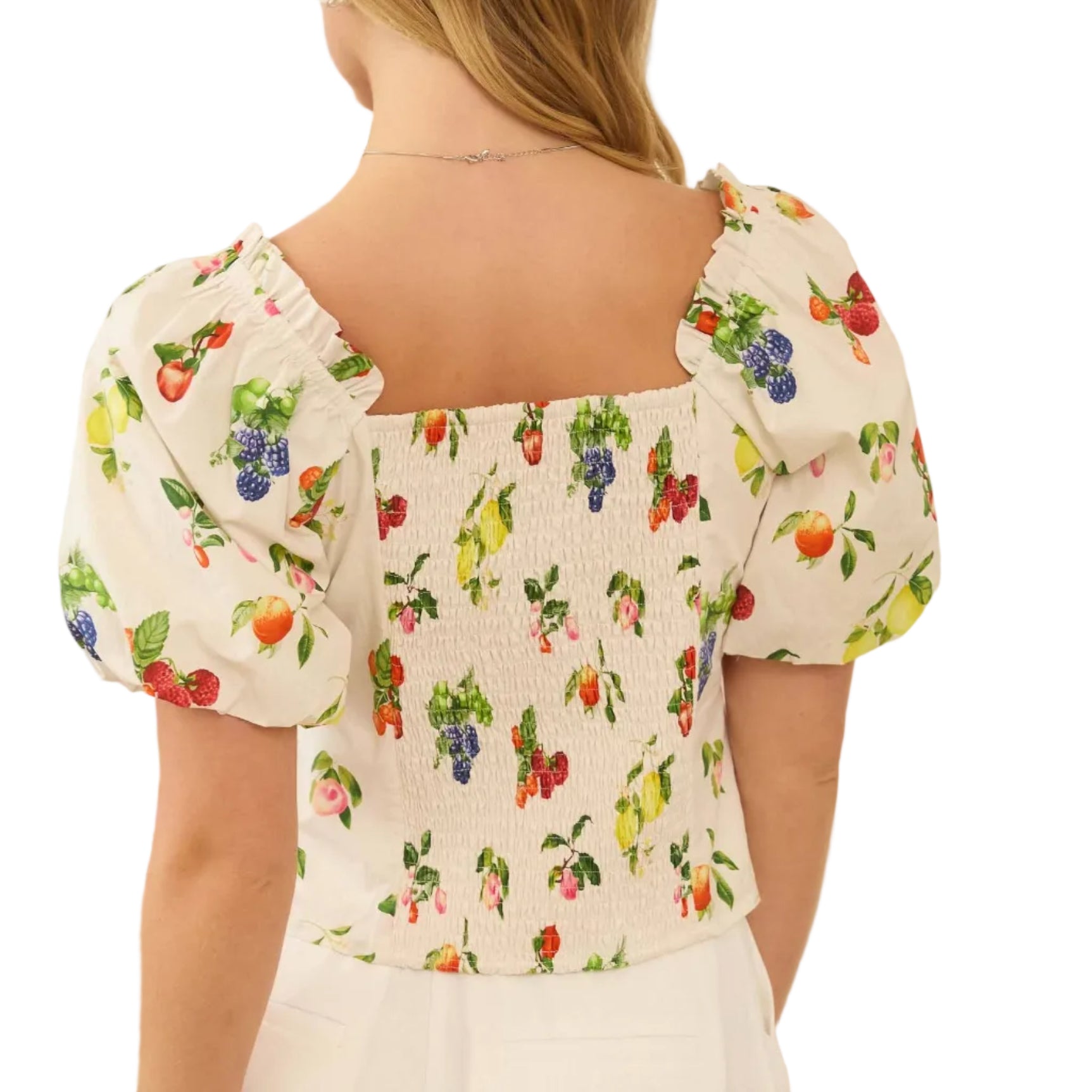 Woman wearing a floral blouse with puffed sleeves in a neutral setting