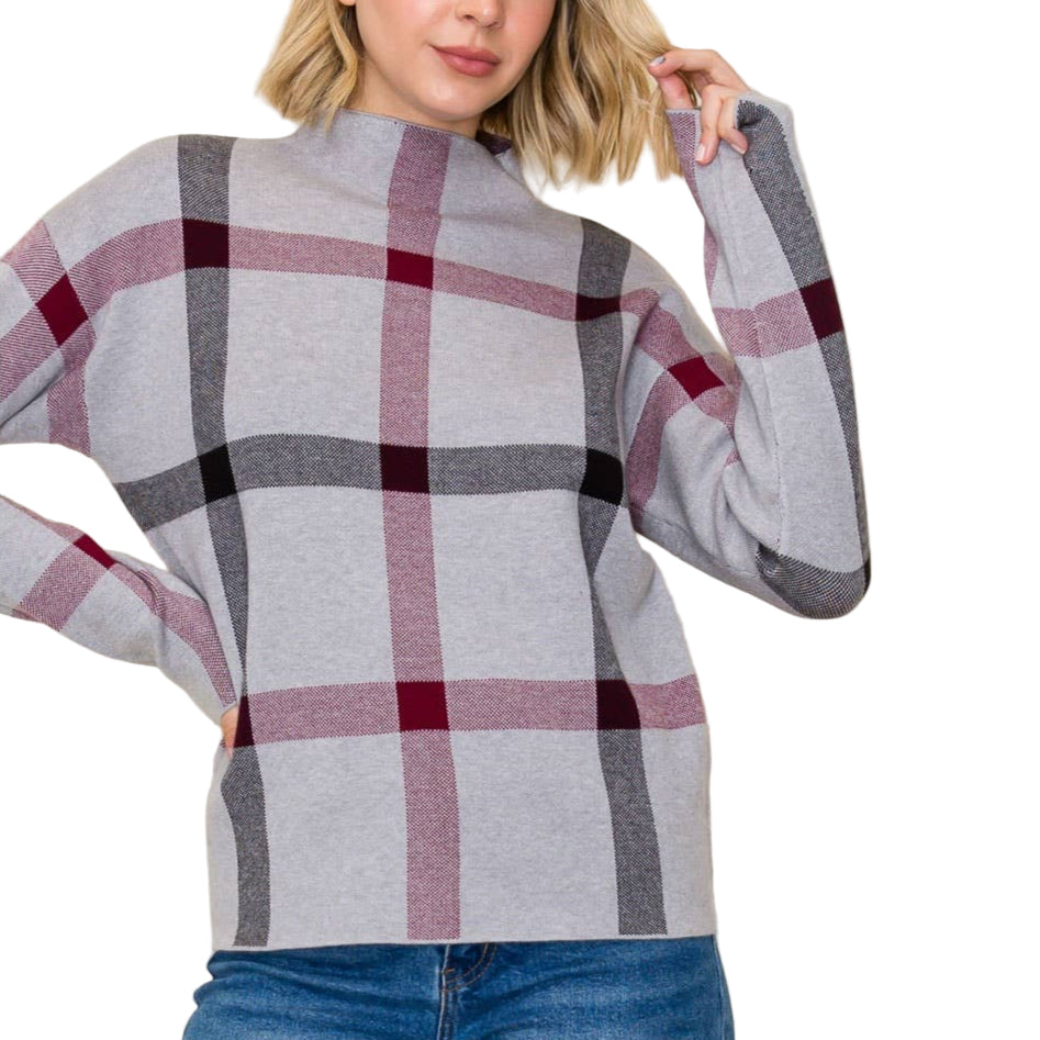 Woman wearing a plaid sweater with a plain background