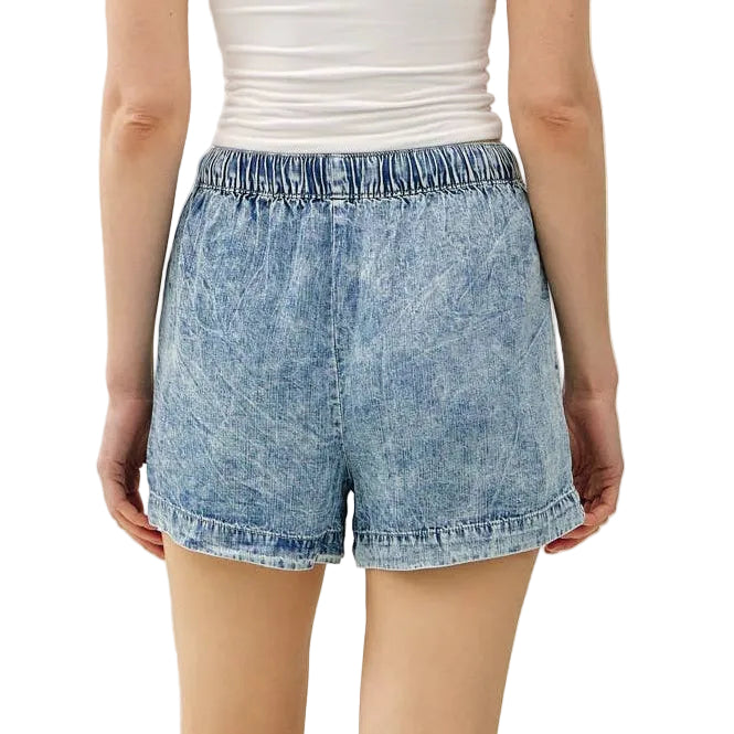 Person wearing a strapless top and denim shorts on a white background