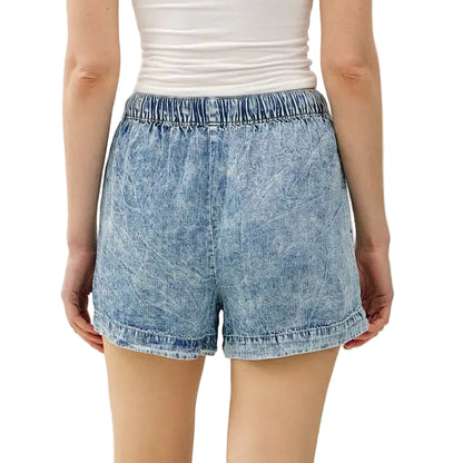 Person wearing a strapless top and denim shorts on a white background