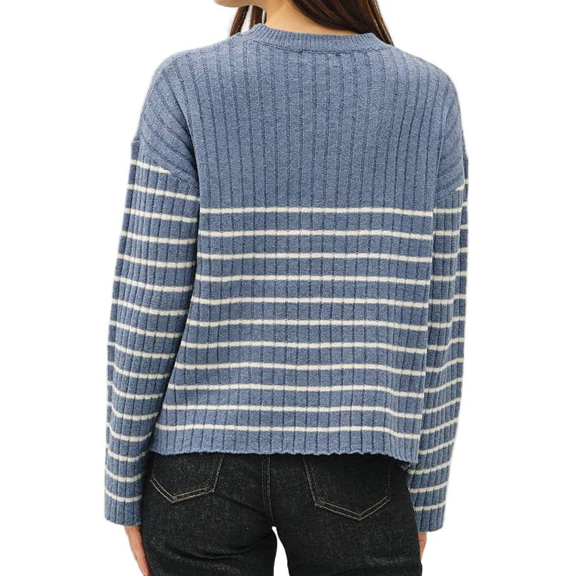 Person wearing a blue striped sweater and dark jeans on a white background