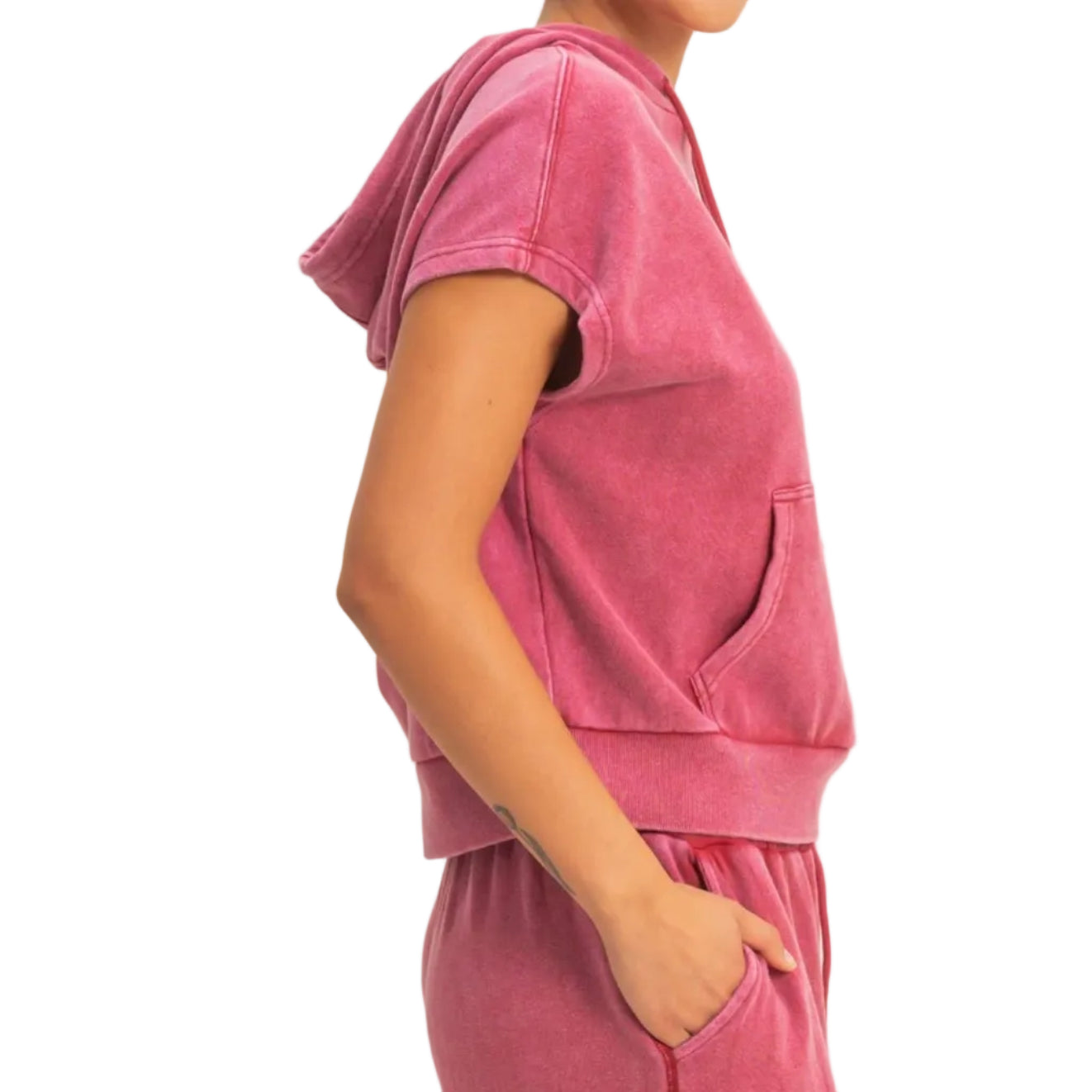 Woman wearing a pink outfit against a plain background