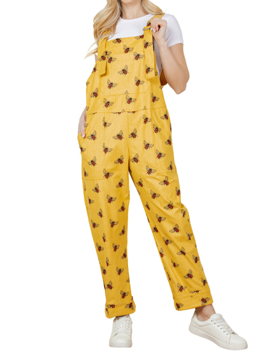Woman wearing yellow floral-patterned overalls against a white background