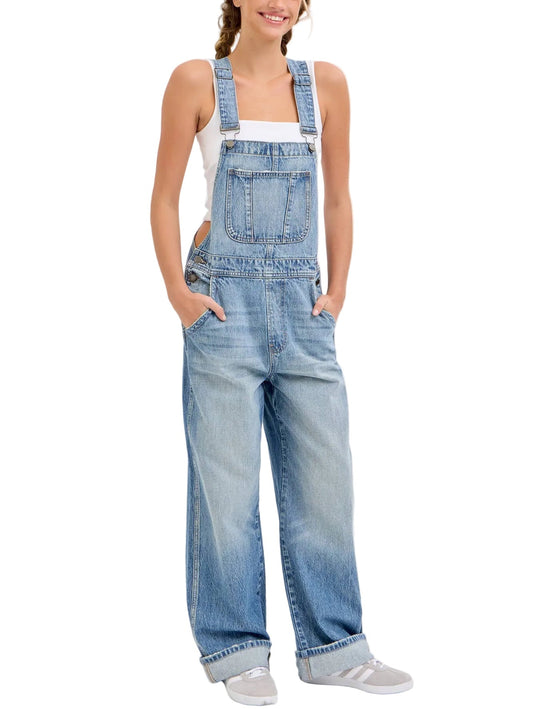 Woman wearing light blue denim overalls on a white background