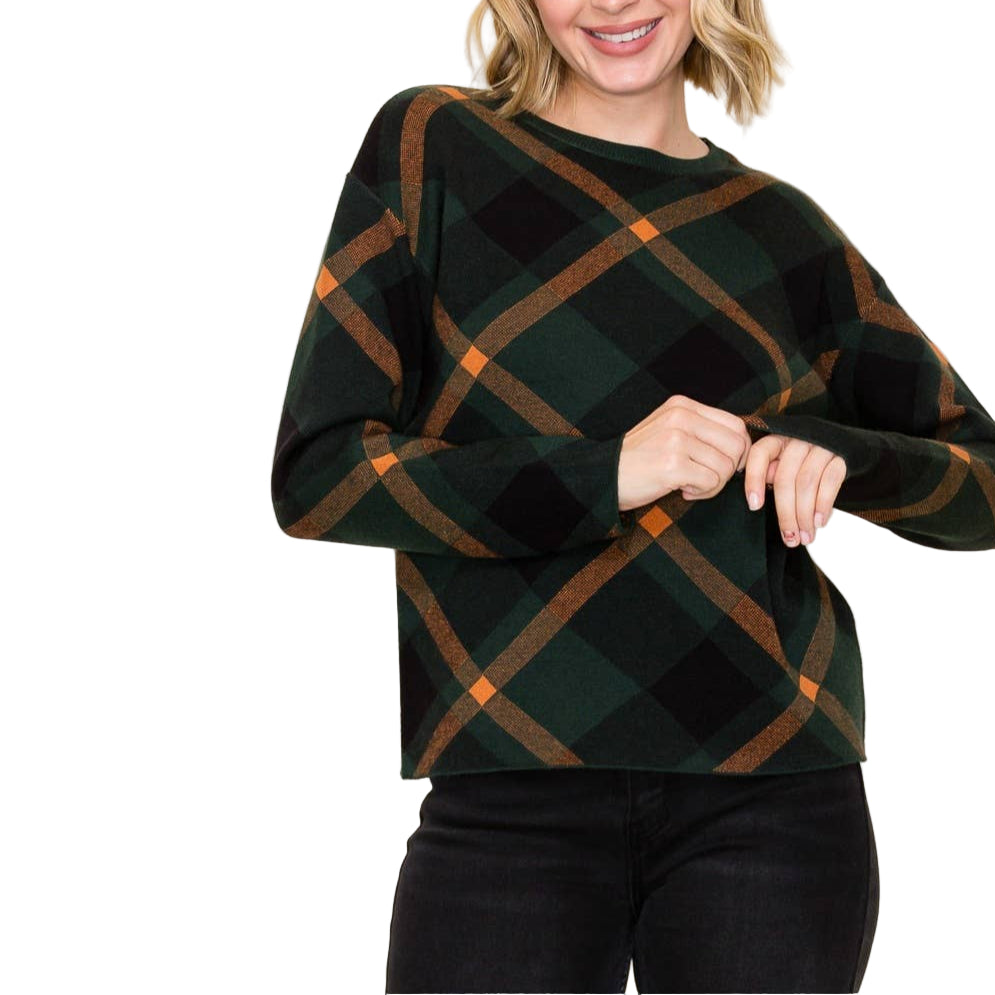 Woman wearing a green and brown plaid sweater against a white background