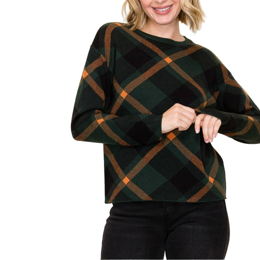 Woman wearing a green and brown plaid sweater against a white background