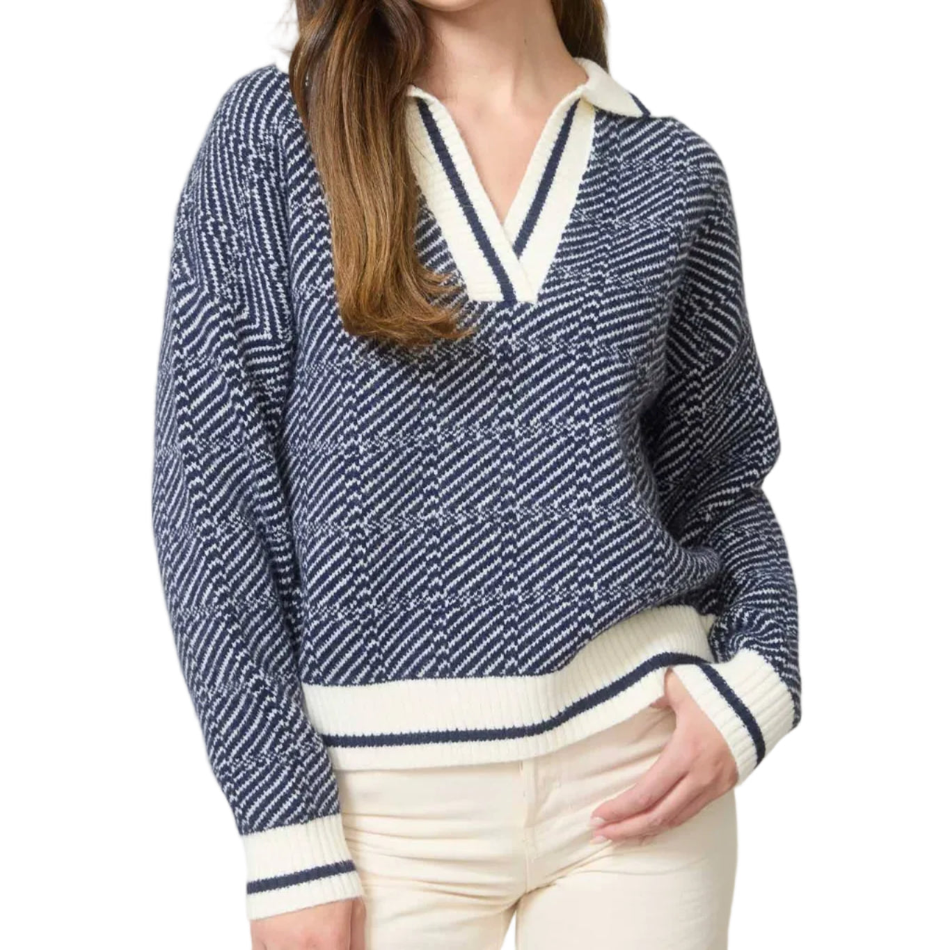 Woman wearing a navy and white patterned sweater with cream pants in an office setting.