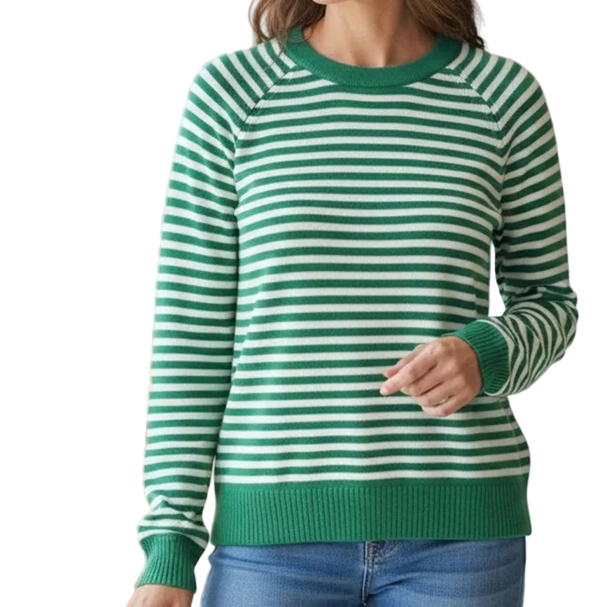 Woman wearing a green and white striped sweater in a bright room.