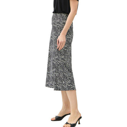 Woman wearing a black top and patterned skirt on a white background