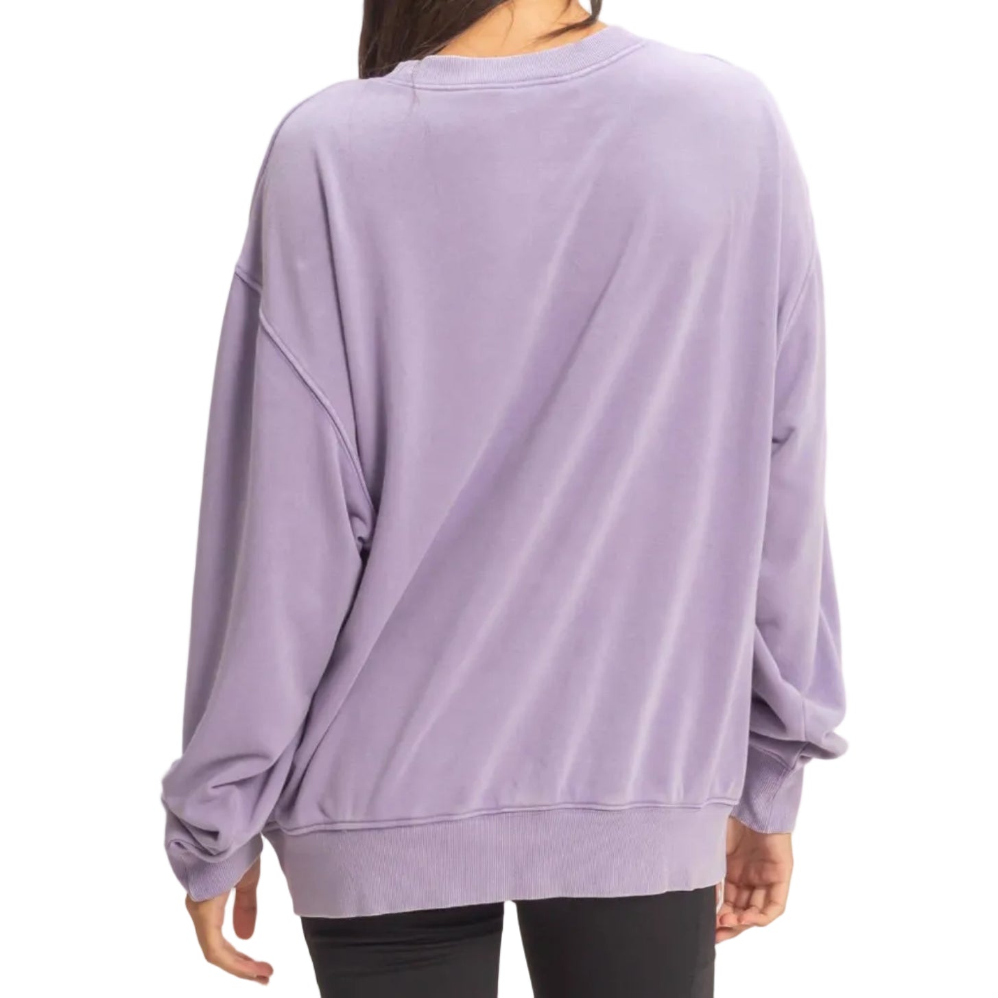 Person wearing a purple oversized sweatshirt and black shorts on a beige background