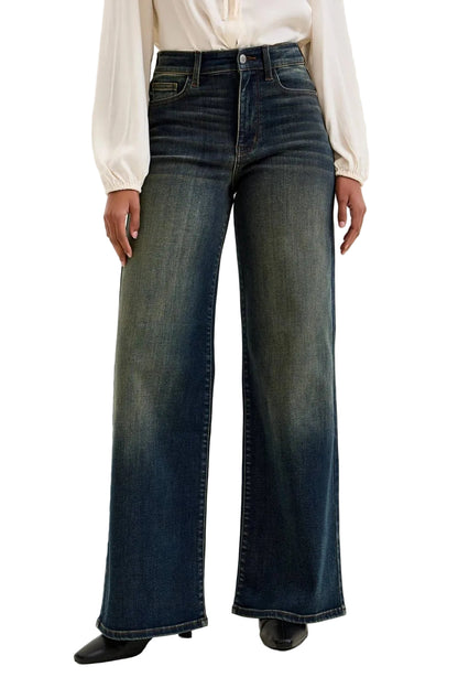 Person wearing dark blue wide-leg jeans on a plain background