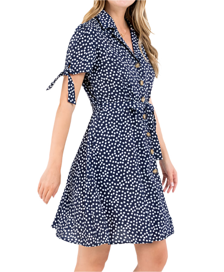 Woman wearing a navy blue dress with white patterns on a white background