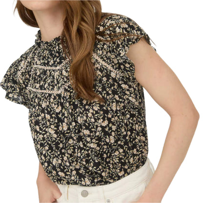Woman wearing a floral blouse with a plain background