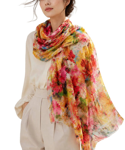 Woman wearing a colorful floral scarf on a plain background