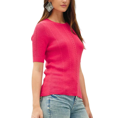 Woman wearing a bright pink top and light blue jeans on a white background