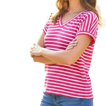 Woman wearing a pink and white striped shirt with a blurred natural background