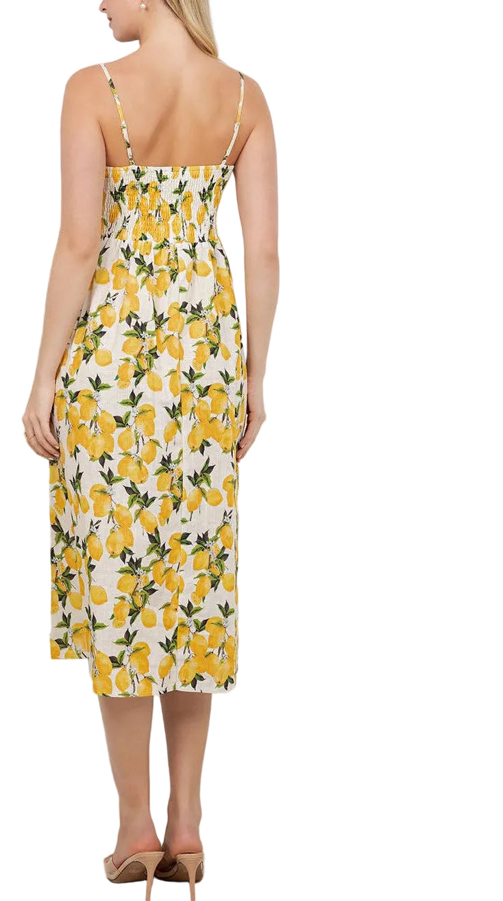 Woman wearing a yellow floral dress in a room with plants