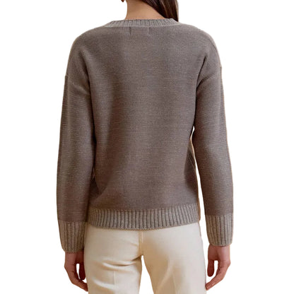 A woman viewed from behind wearing a gray knit sweater and off-white wide-leg pants, standing against a solid beige studio background.
