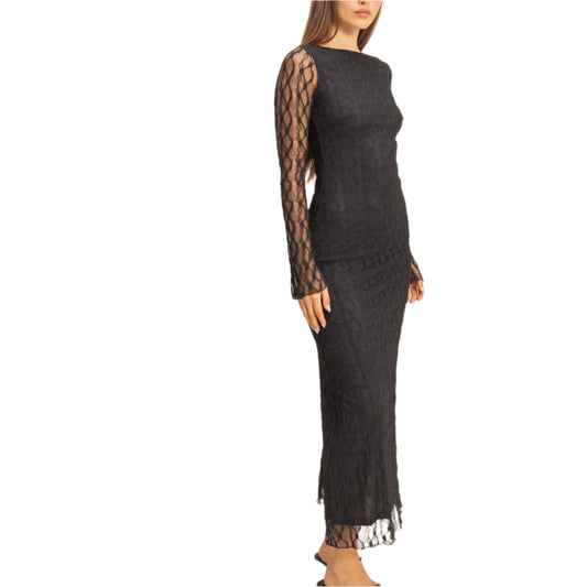 Woman wearing a black lace dress against a plain background