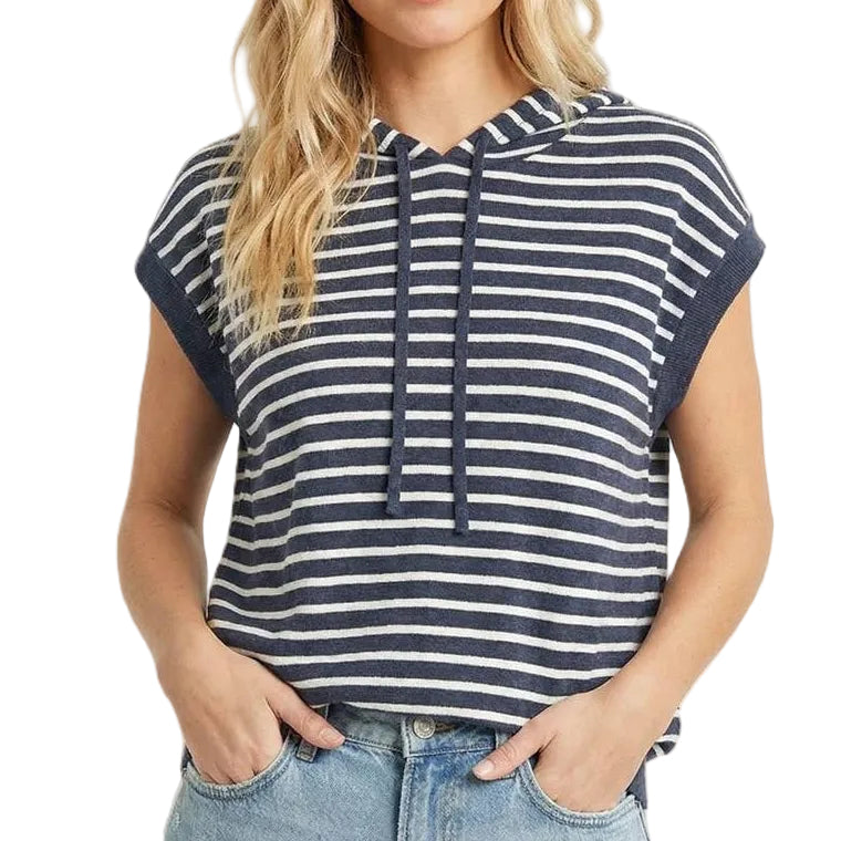 Woman wearing a striped shirt and denim shorts on a beige background