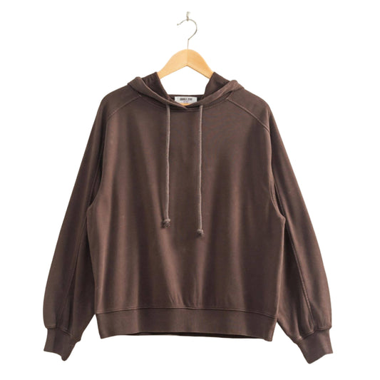 Brown hoodie on a hanger against a plain wall