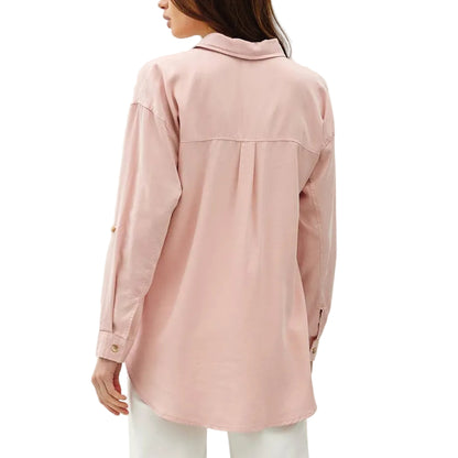 Woman wearing a light pink shirt and white pants on a white background