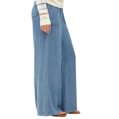 Woman wearing a striped sweater and wide-leg jeans on a white background