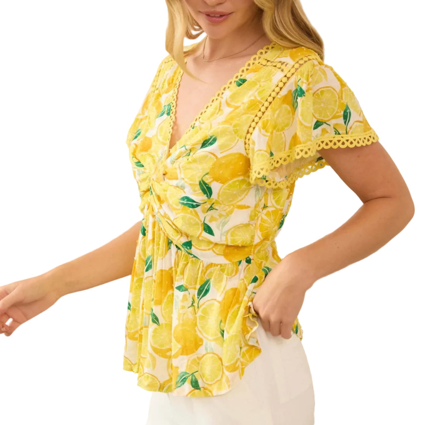 Woman wearing a yellow lemon print top in a bright room