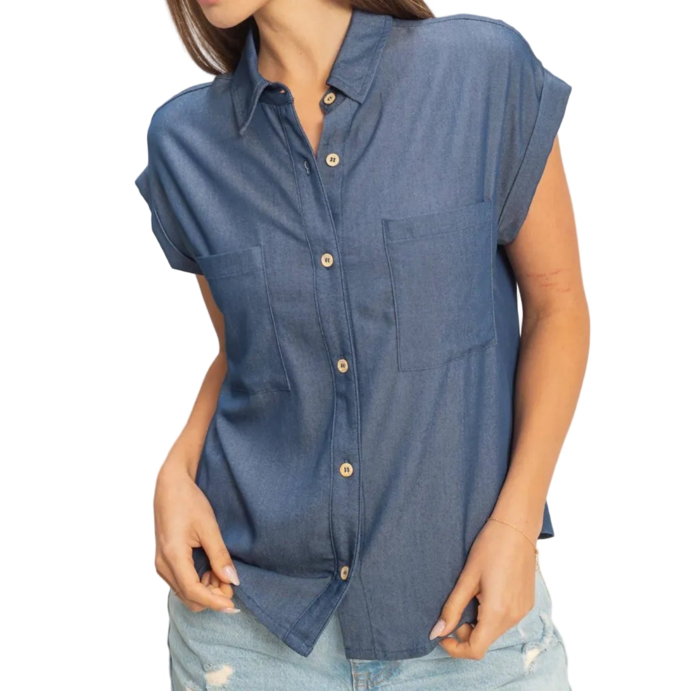 Woman wearing a blue sleeveless shirt with a plain background