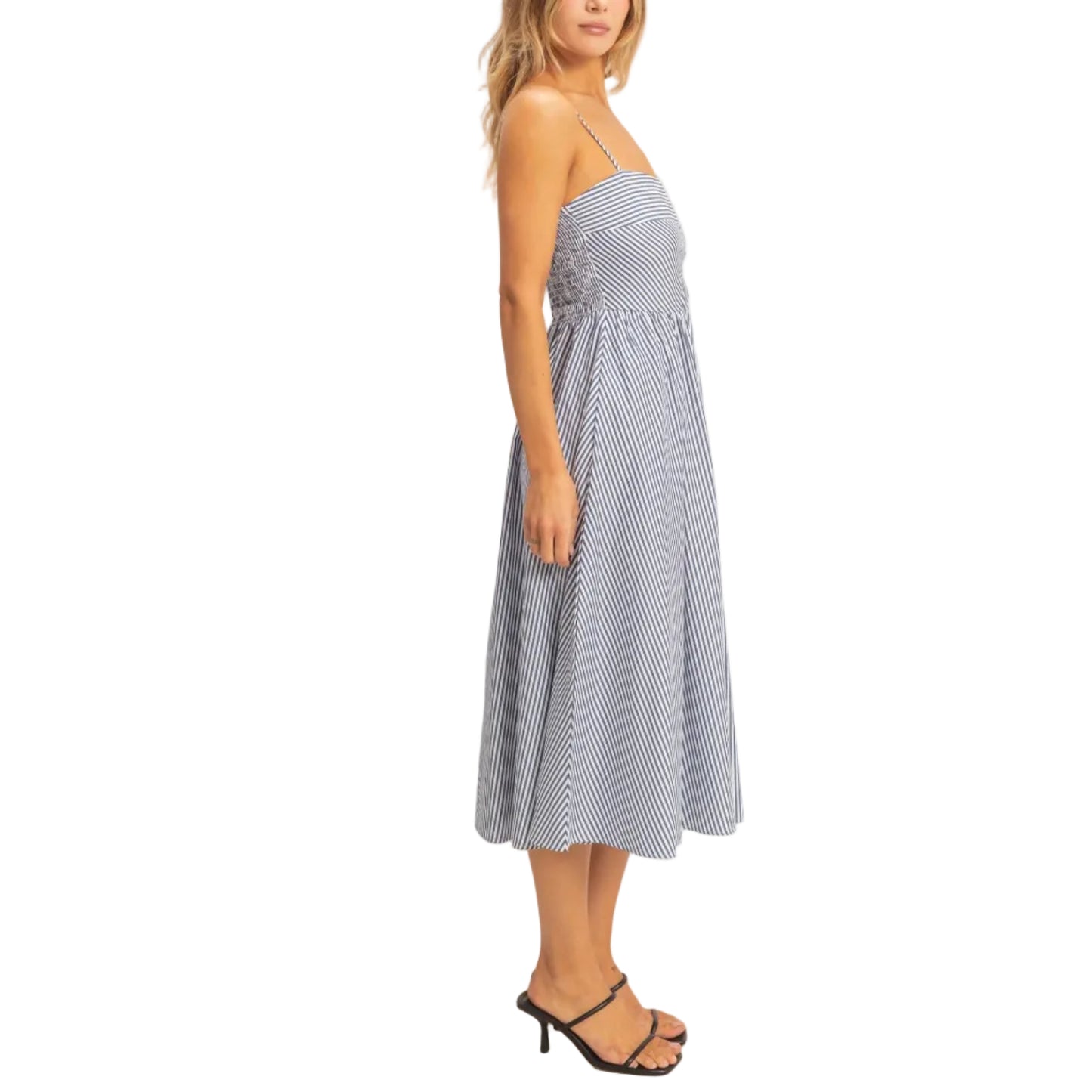 Woman wearing a blue and white striped dress against a plain background