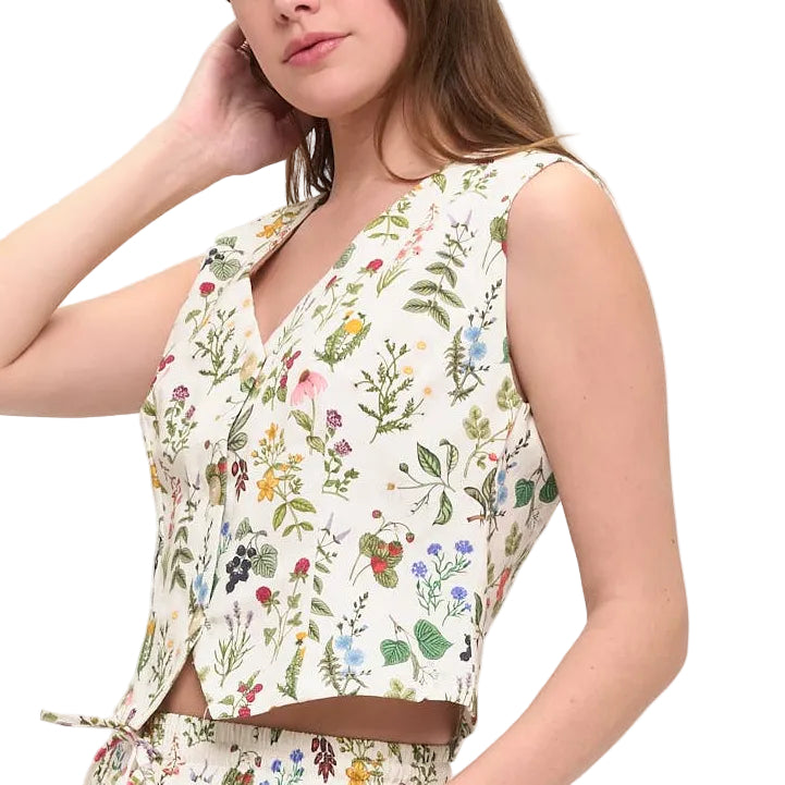 Woman wearing a floral dress with a vest on a white background