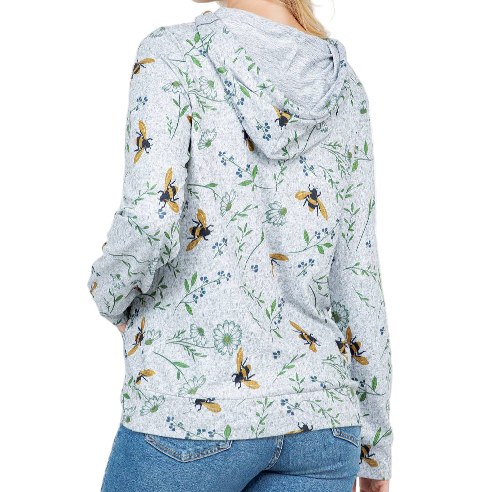 Woman wearing a floral hoodie with bee pattern on a white background