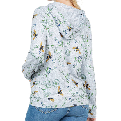Woman wearing a floral hoodie with bee pattern on a white background