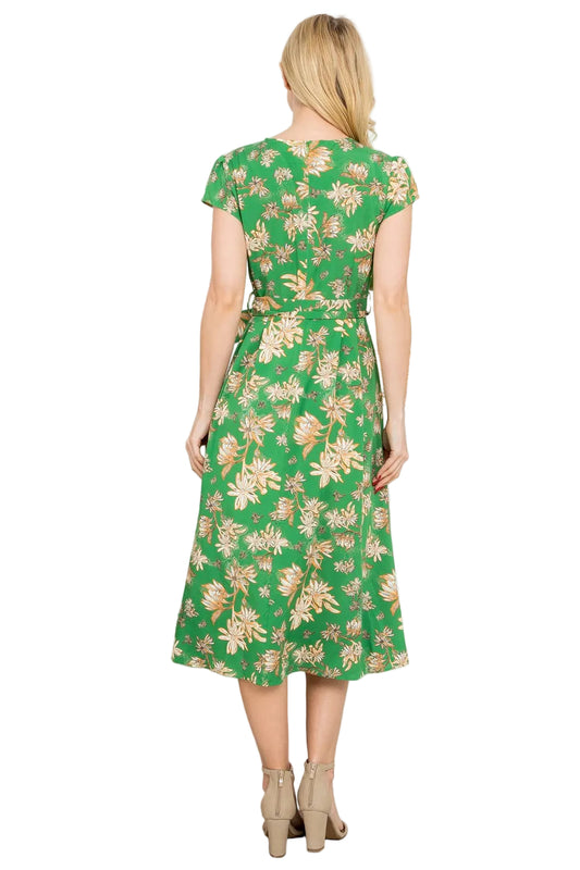 Woman wearing a green floral dress in a room with plants