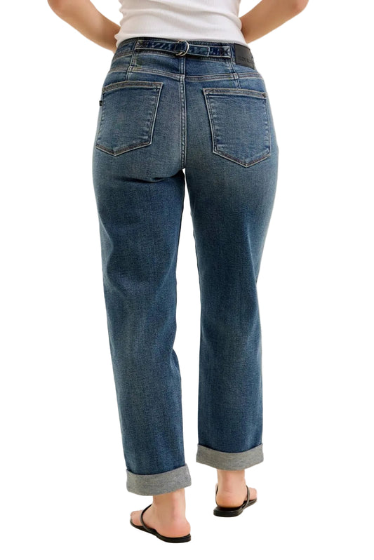 Person wearing blue jeans on a plain background