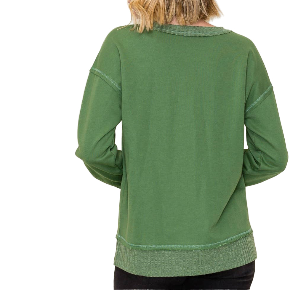 Green sweater worn by a person on a white background