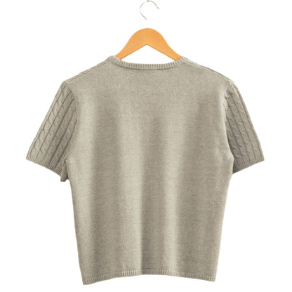 Gray sweater on a hanger against a beige wall