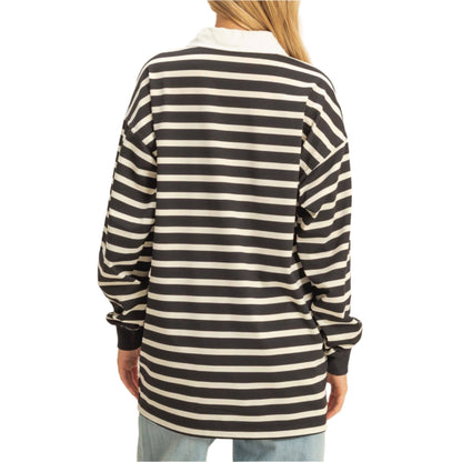 Person wearing a black and white striped long-sleeve shirt on a beige background